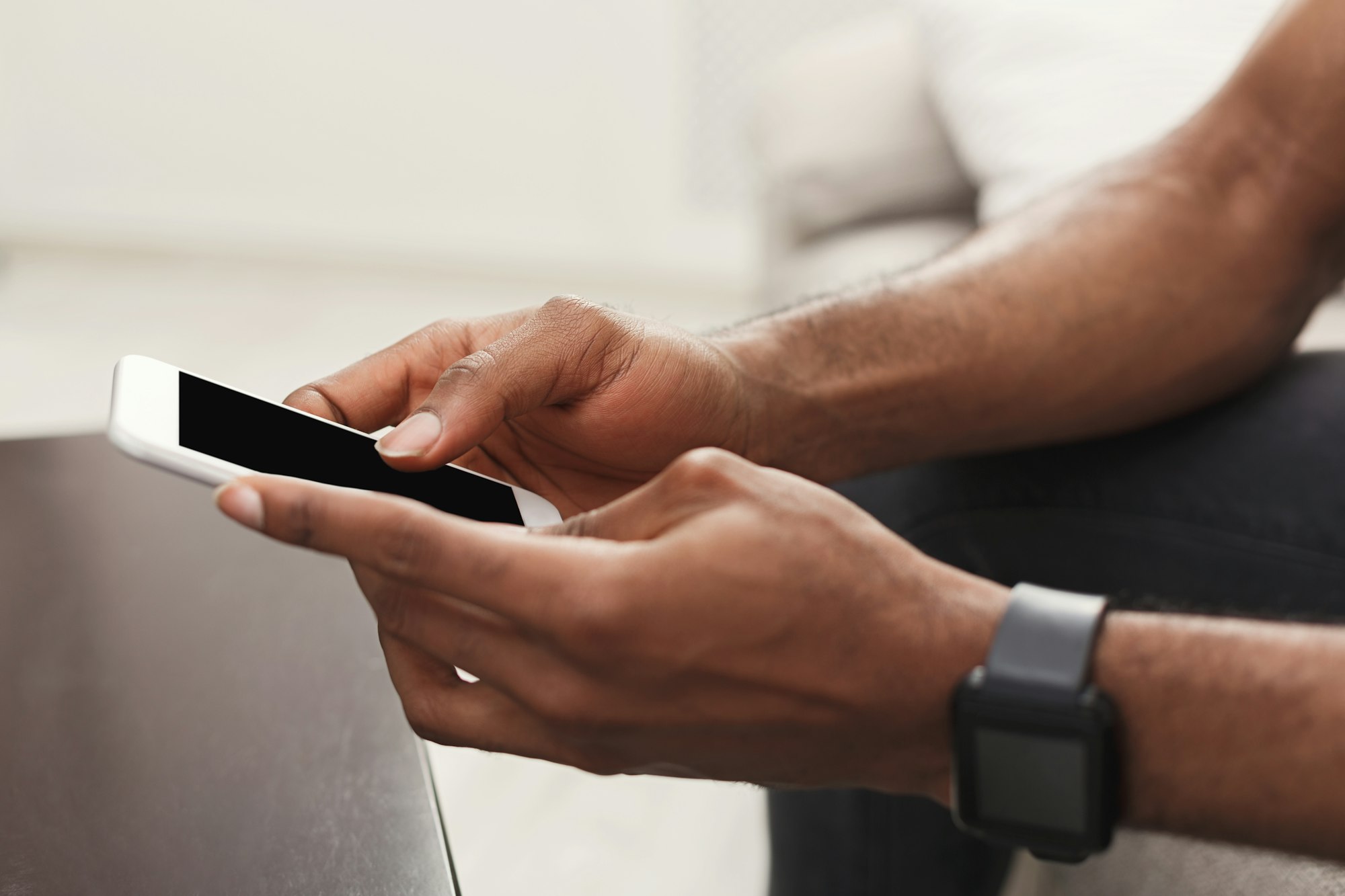 Closeup of male hands using smartphone with blank screen